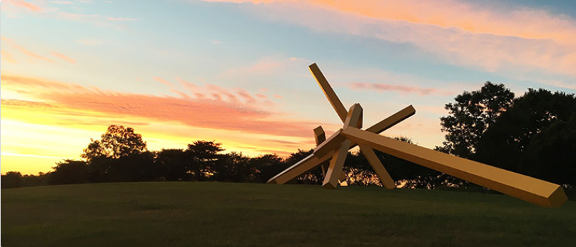 A large yellow steel sculpture titled ‘Illinois Landscape No. 5’ at sunset