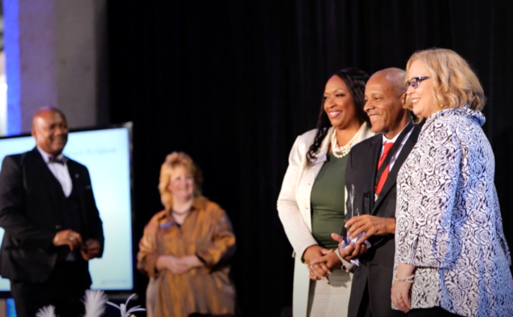 Alum receiving award on stage