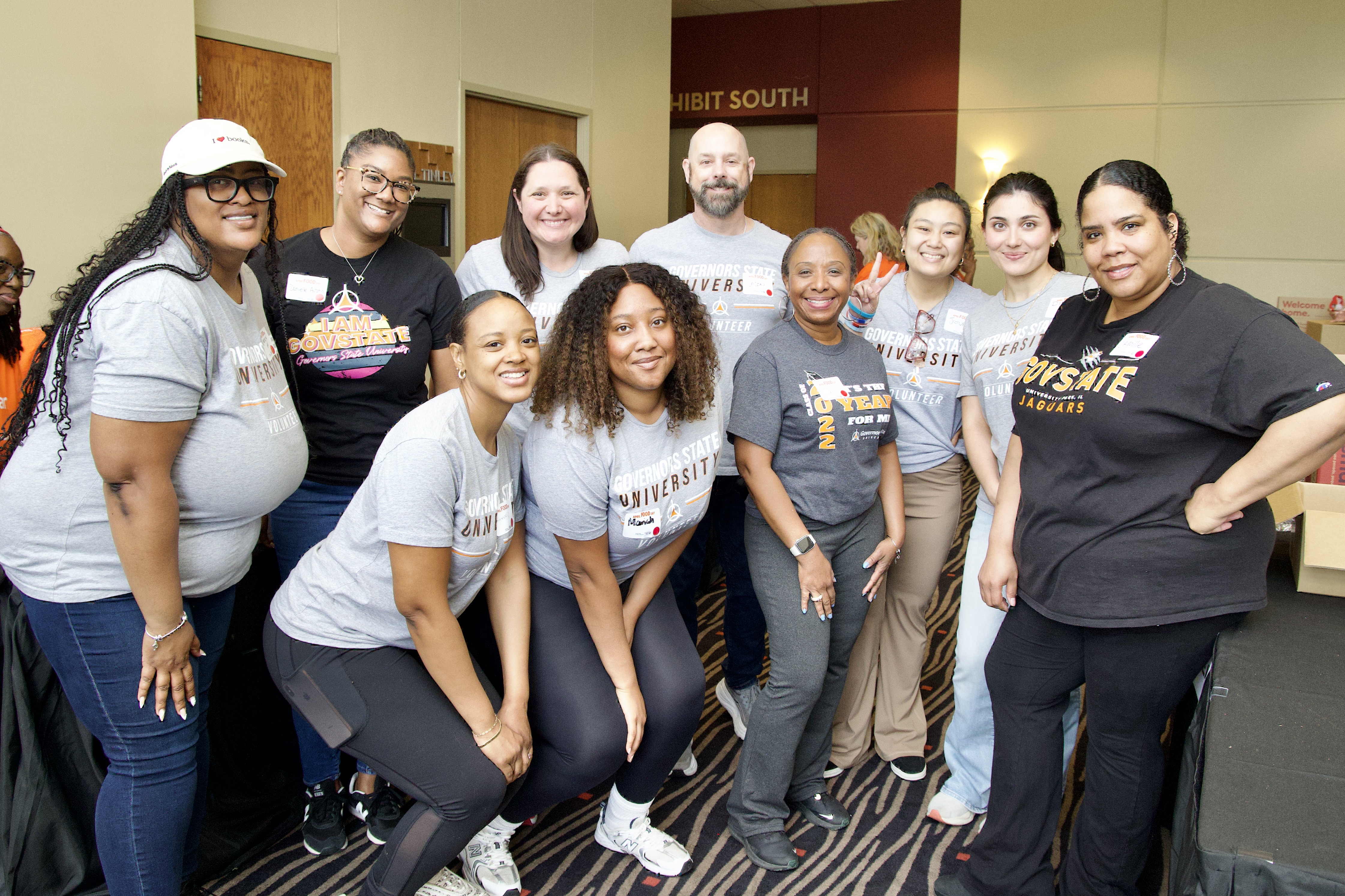 A group of Governors State University staff, student and alumni volunteers smiling for a photo on April Food Day.